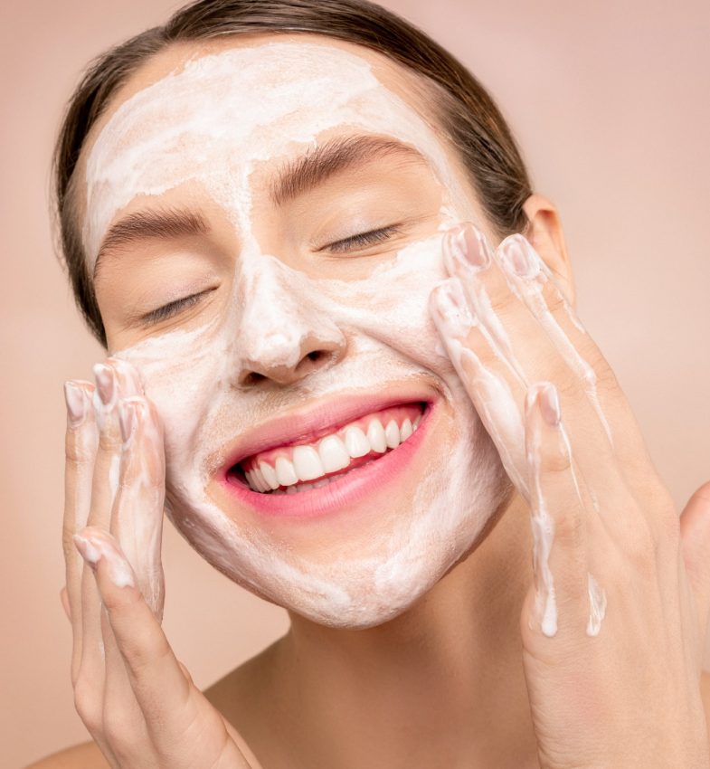 smiling woman moisturising her face