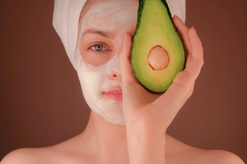 woman wearing face mask, holding fruit
