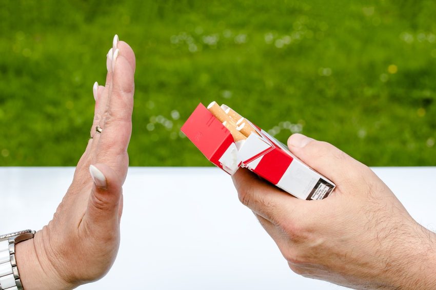 one hand holds out pack of cigarettes, another refuses, stop smoking